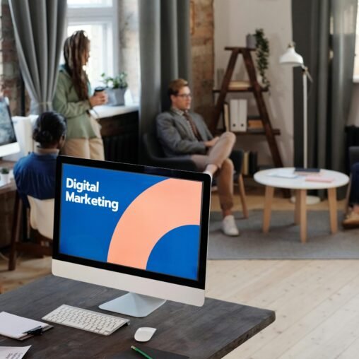 People Having a Meeting Behind a Computer Screen that says Digital Marketing